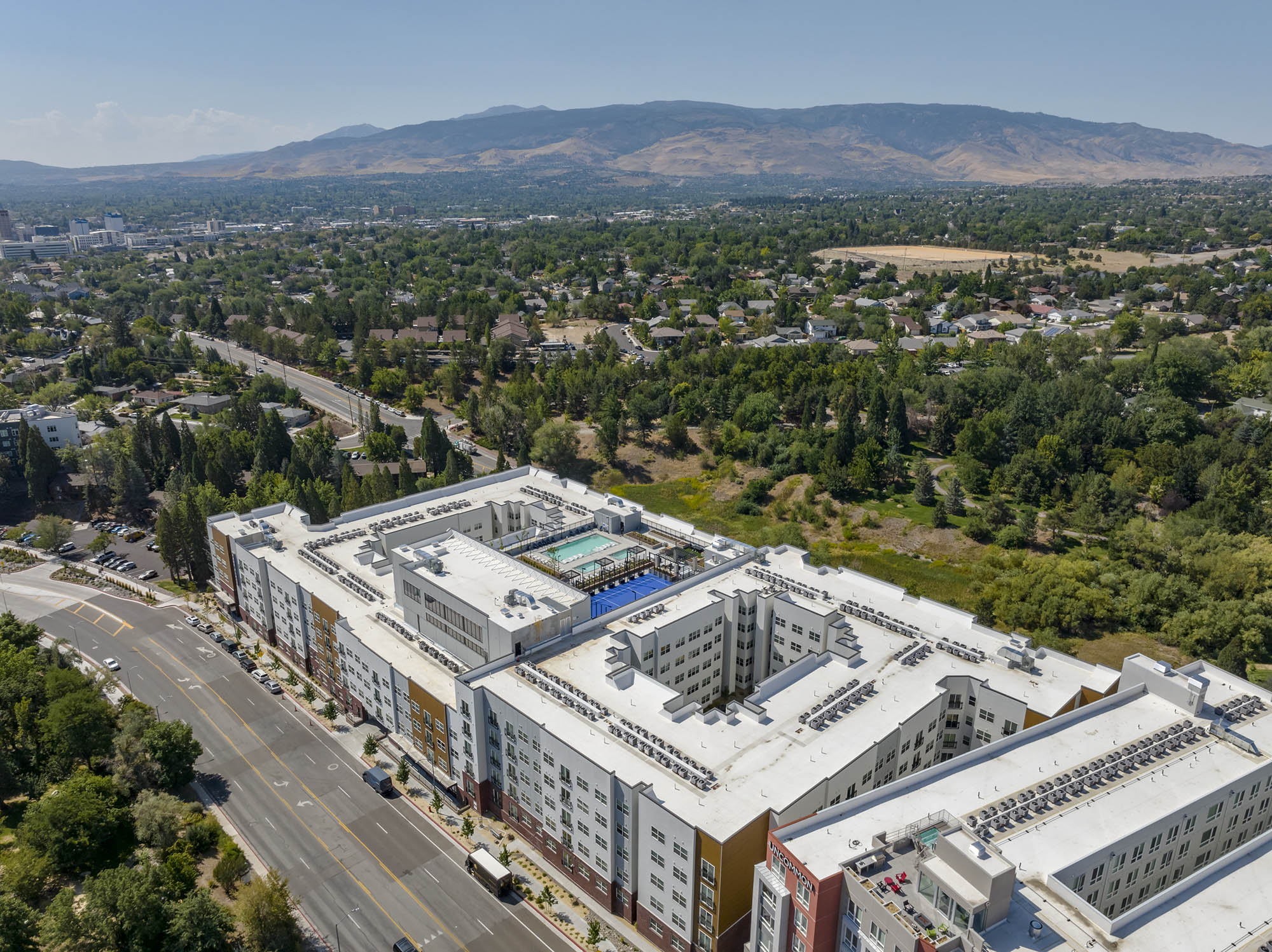 Aerial view of an apartment complex near a green landscape