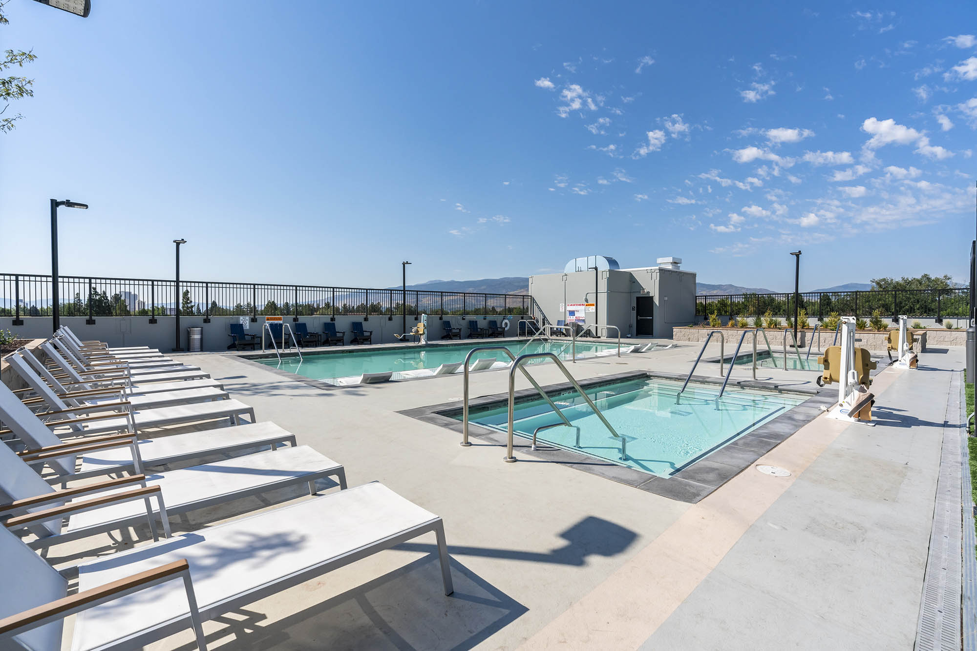 rooftop pool area with lounge chairs two pools a